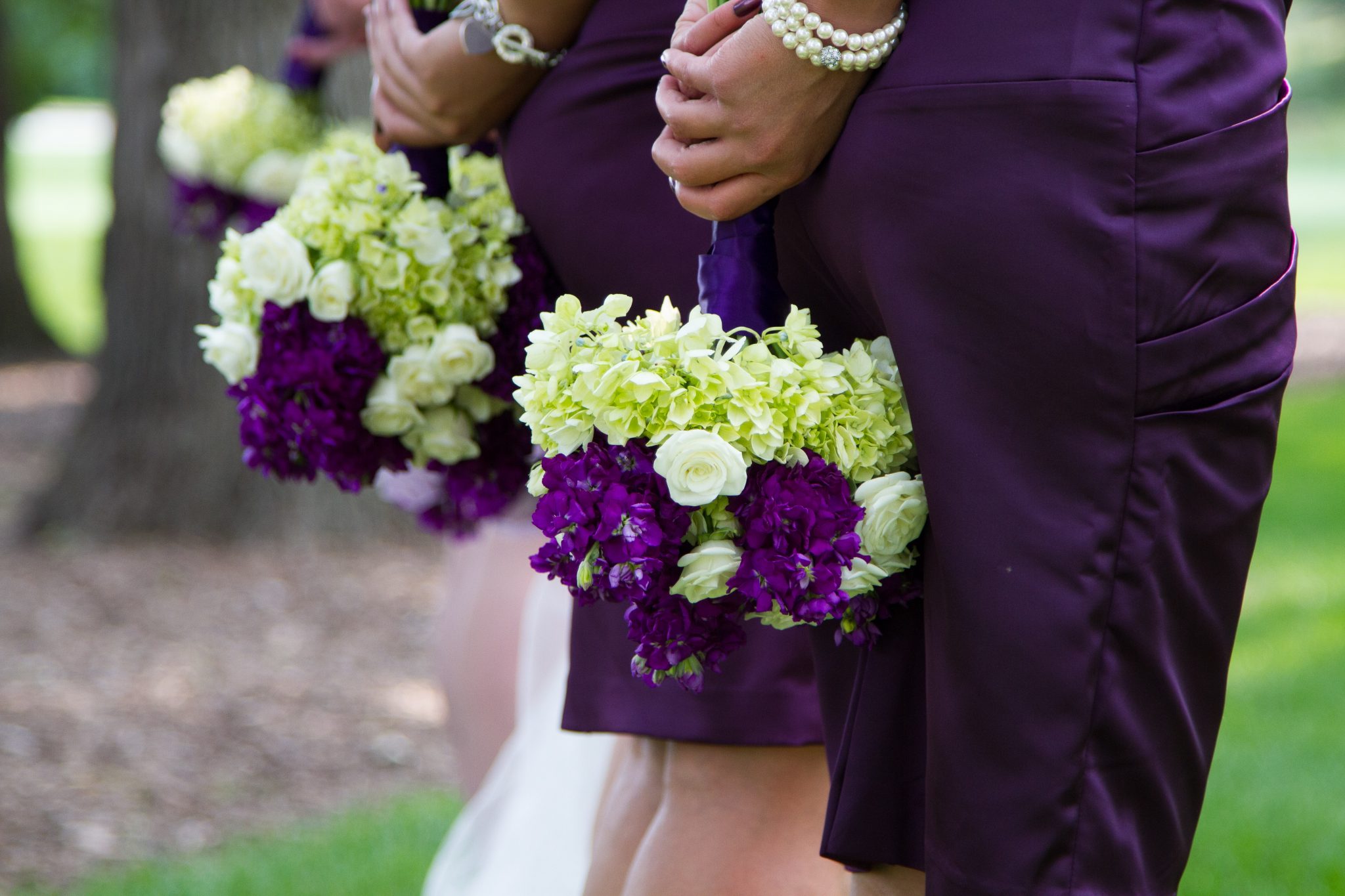 Lime green hydrangea make these bouquets pop against purple dresses. Purple stock and white roses complete the bouquets.