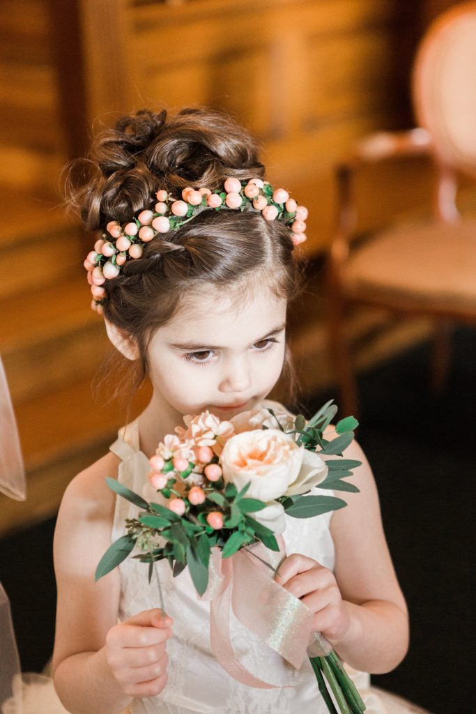 Miniature clutch bouquet of peach garden roses, stock, and hypericum for the flower girl with matching crown of hypericum berries.